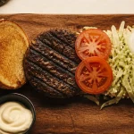 Hamburger whopper avec steak grillé, salade, tomates et cornichons